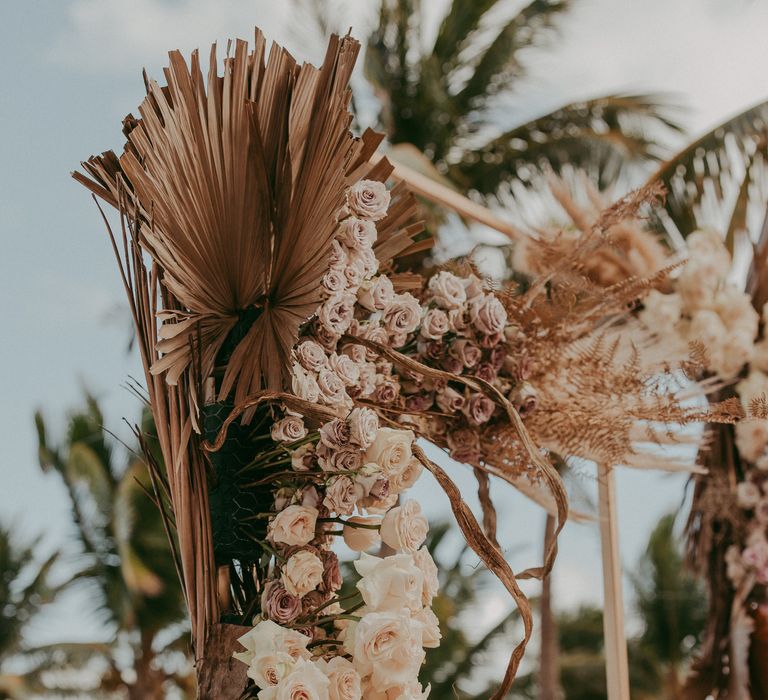 Dried florals line the aisle of beach wedding in Mexico 