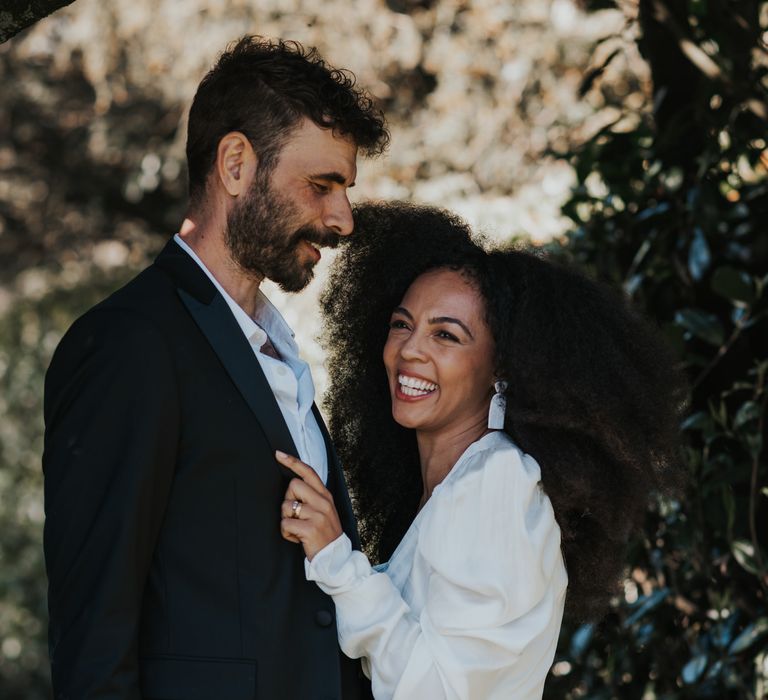 Beautiful Black bride with afro hair smiling with her groom 