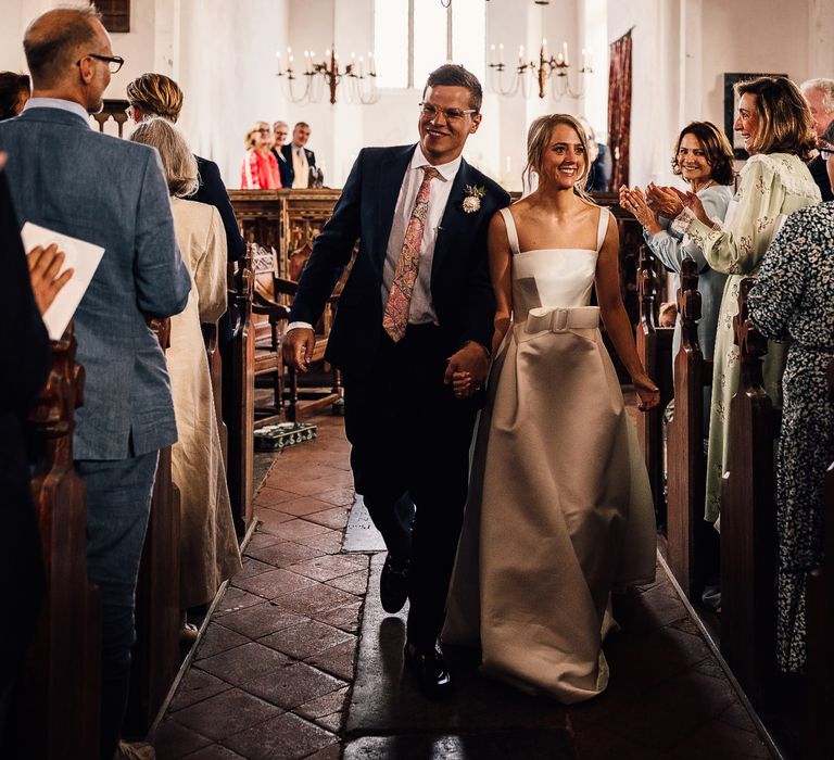 Bride and groom walk down the aisle at church wedding