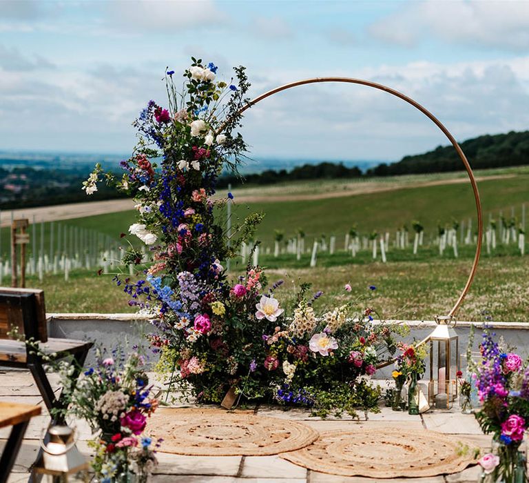 Copper frame moon gate decorated with colourful wildflowers at Little Wold Vineyard