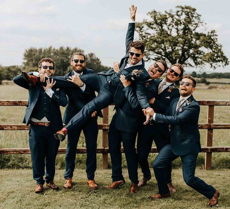 Groom with groomsmen in matching blue wedding suits