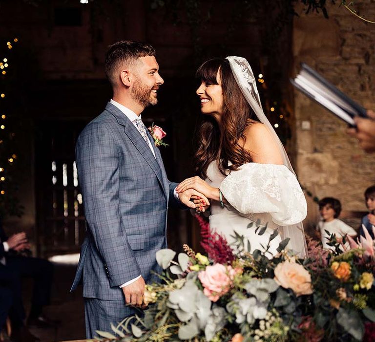 Bride & groom look lovingly at one another on their wedding day during ceremony