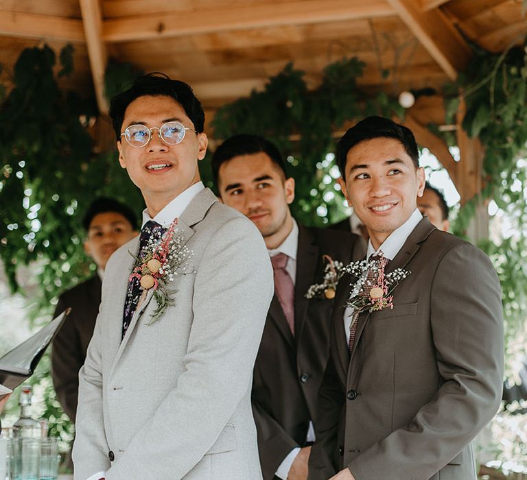 Groom looks toward his bride as she walks down the aisle on her wedding day