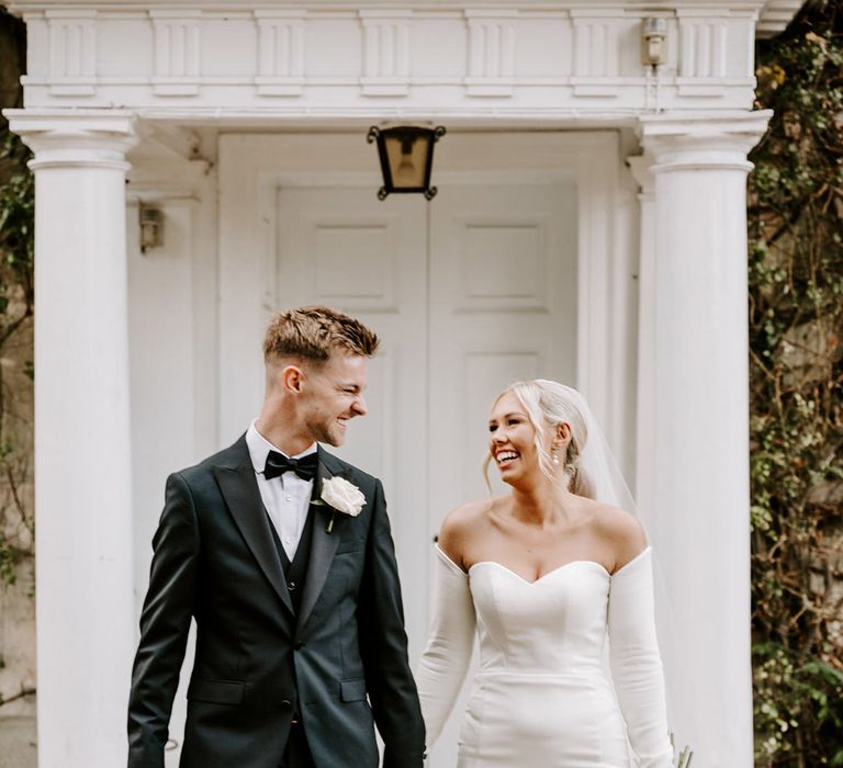 Black tie wedding at Northbrook Park with groom in a tuxedo and bride in a strapless wedding with detachable long sleeves 