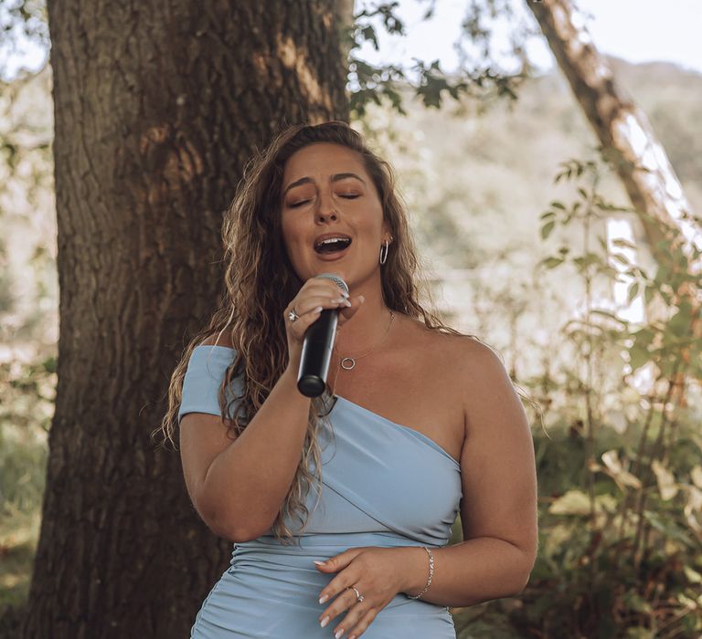 Singer wears pale blue gown as she sings before bride walks down the aisle 