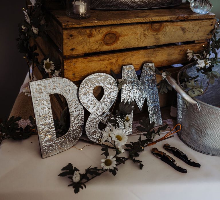 Metal D and M letters next to beer bucket and glasses for rustic chic wedding ceremony