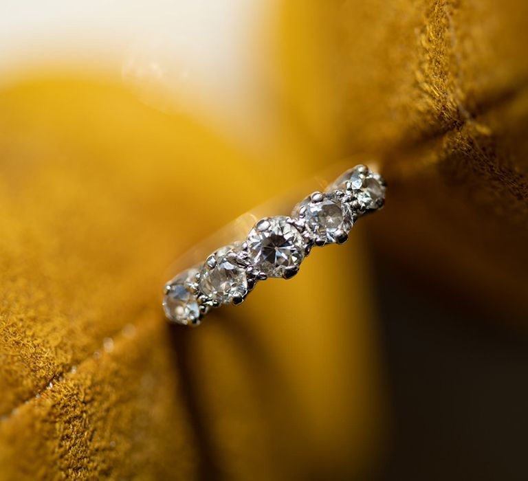 Diamond wedding ring against yellow background