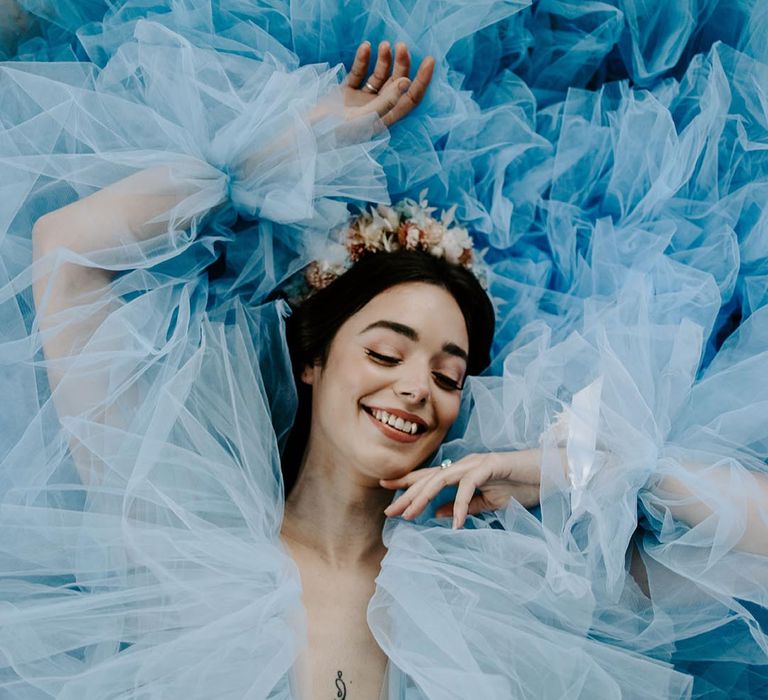 Bride laying down in a blue Millia London wedding dress