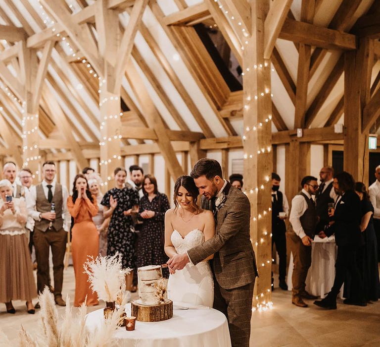 Bride and groom cut their rustic wedding cake