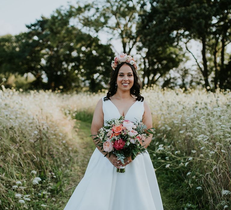 Bride in Stella York wedding dress with bright pink wedding bouquet and matching flower crown