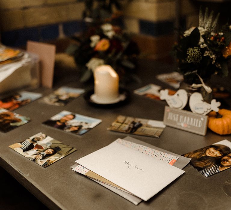 Table of photos of the newlyweds with cards from the attending wedding guests