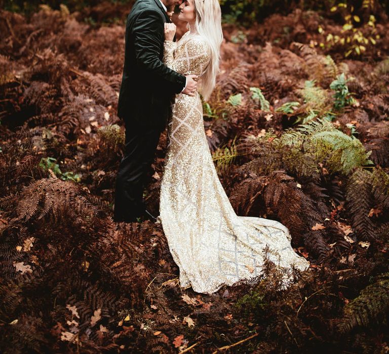 Bride wears gold sequin wedding dress with long sleeves and a bridal crown in her long blonde hair 