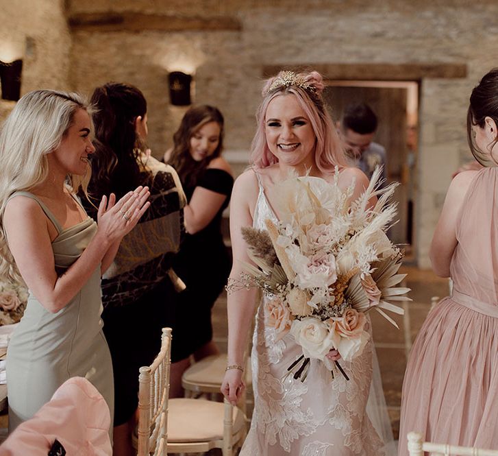 Bride with pink hair wearing floral bridal crown holds dried floral bouquet with pampas grass 