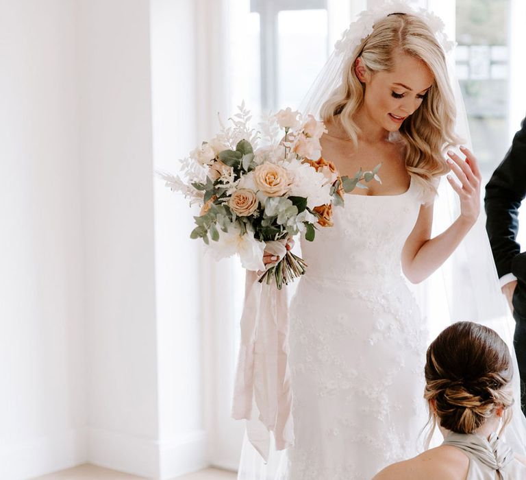 Bridesmaids help the bride with finishing touches before the big day