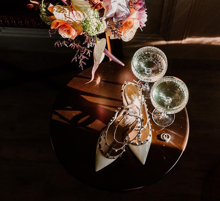 Pointed studded Valentino wedding heels with glasses of alcohol 