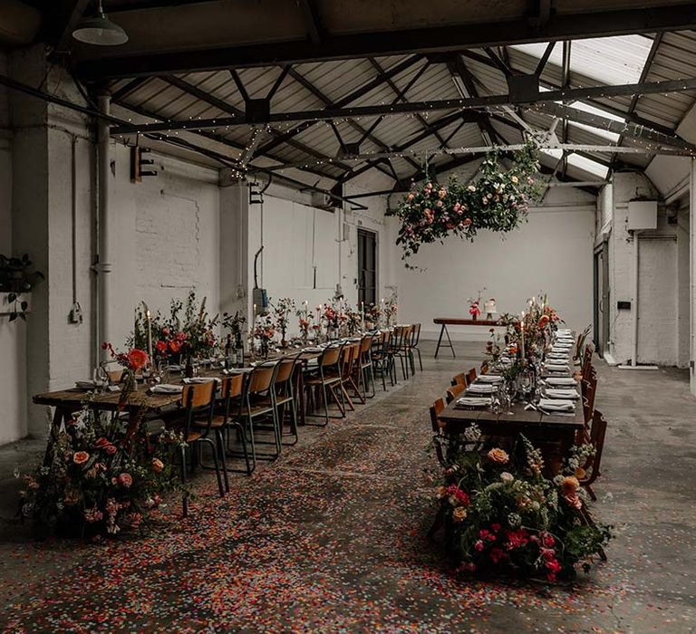 Wedding reception room at Hackney Studios with neutral, minimalistic tablescapes and pops of bright colour in the floral decorations