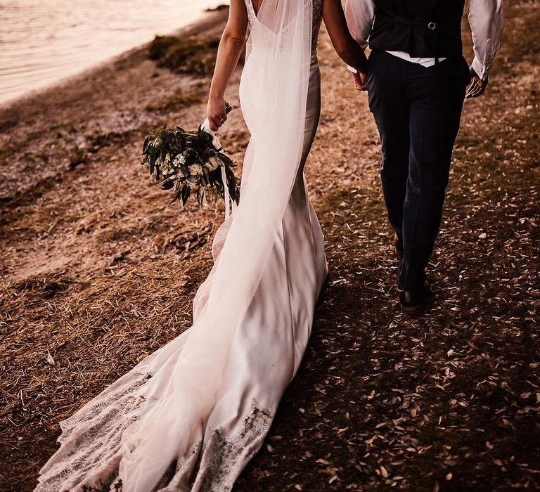 The bride and groom walk around the stunning land surrounding Pylewell Park wedding venue