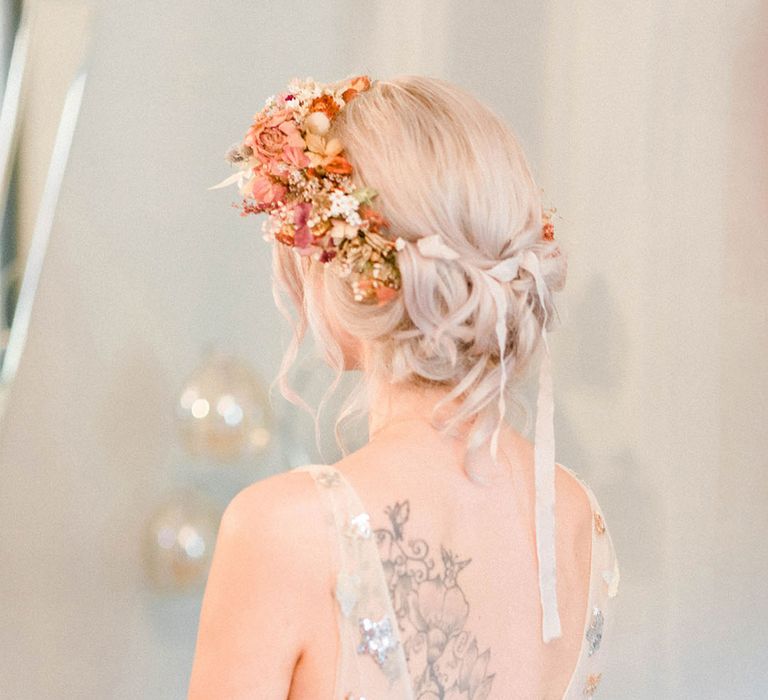 Bride wears sheer wedding dress finished with sequinned stars and flower crown in her blonde hair