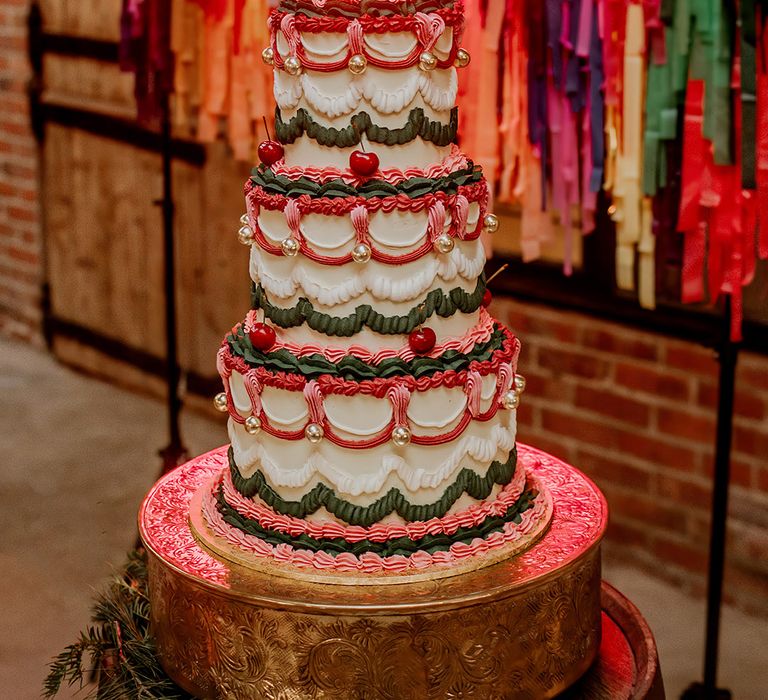 Three tier retro wedding cake with pink, green, purple and white icing and cherry and disco ball decorations 