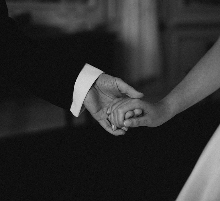 The bride and groom hold hands for their traditional country house wedding at Brympton House 