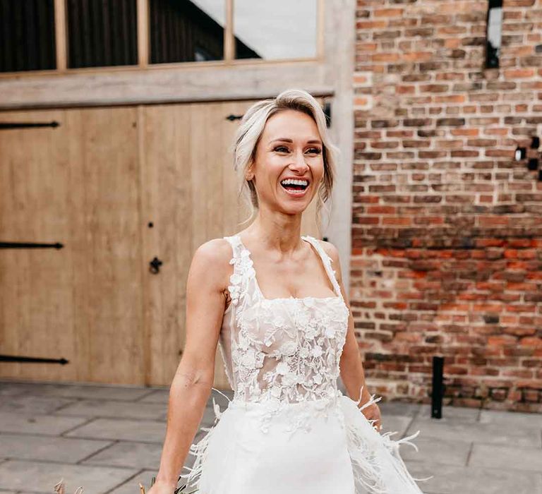 Bride wearing corset top sheer floral 3d appliqué wedding dress with fringe overlay from Nori Ivy 