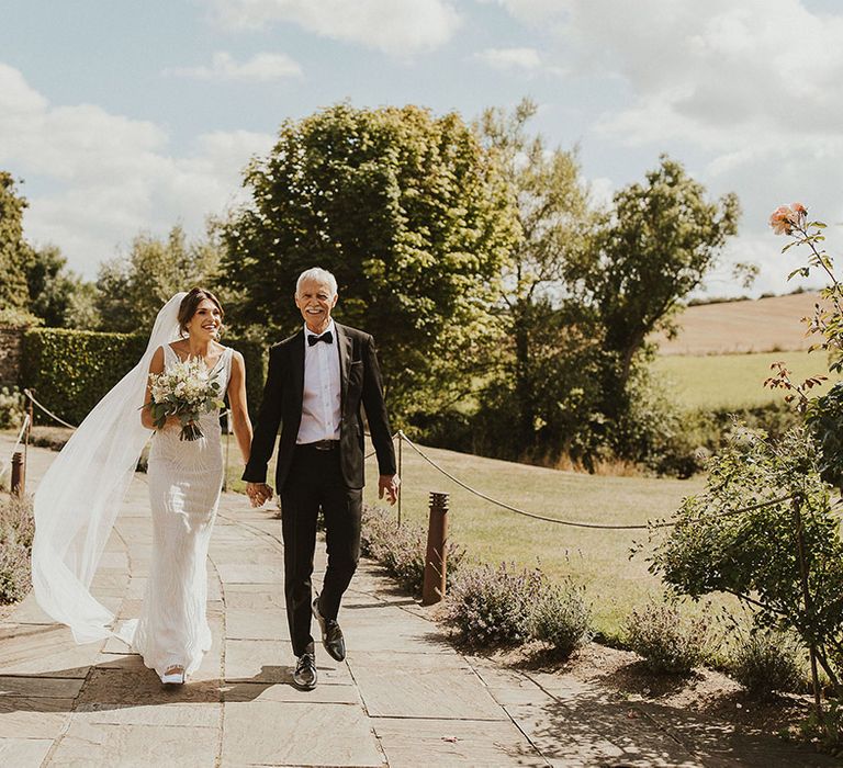 Father of the bride in black tie suit walks the bride to the wedding at Priston Mill, Bath 