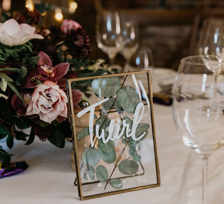 Rustic wedding table sign with gold photo frame with pressed leaved named after different chocolate bars 