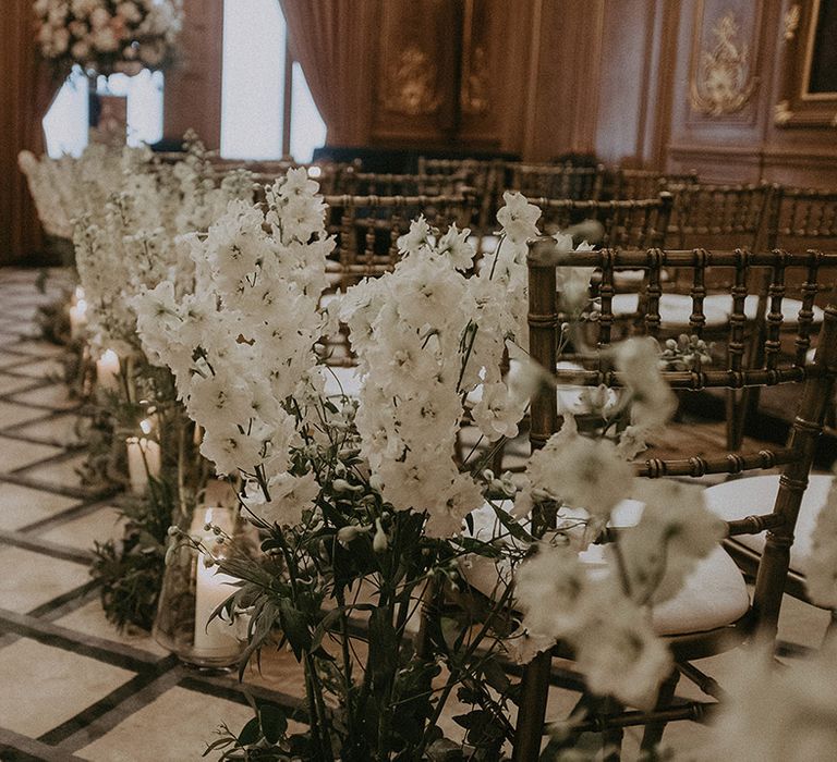 White wedding flowers decorate the aisle of the hotel city wedding venue in London for classic and traditional wedding