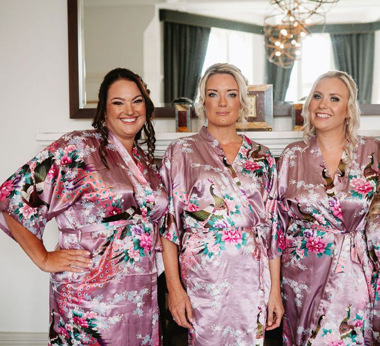 Bridal party getting ready for the wedding in purple patterned satin robes 