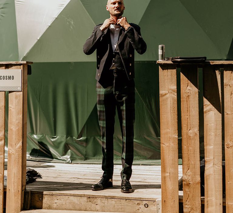 Groom gets ready for the wedding day wearing black tie and bespoke custom green checkered wedding trousers 