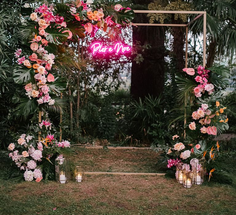 gold frame altar decorated with tropical pink wedding flowers and a personalised neon pink wedding sign