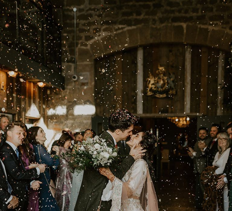 The bride and groom exit their interfaith wedding ceremony to confetti 