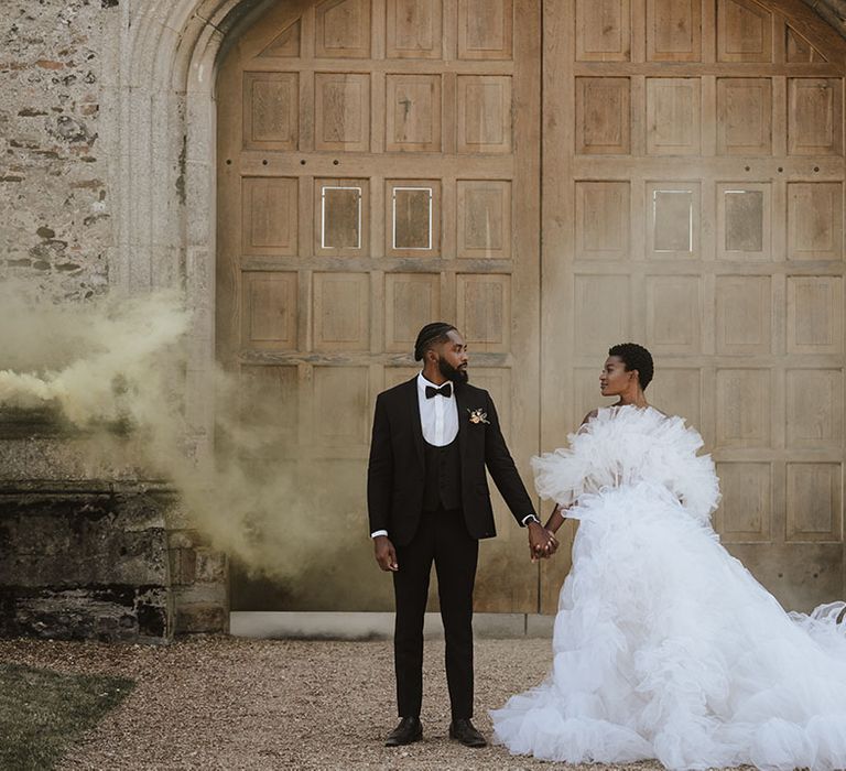 Bride and groom release yellow smoke flare for wedding couple photo 