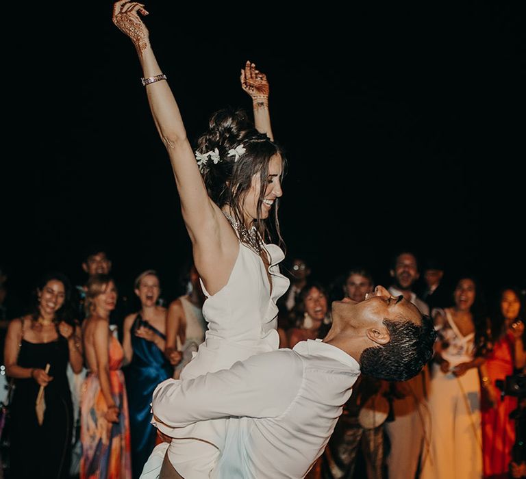 Groom holding his bride in the air during first dance at Tigre Del Mar wedding reception