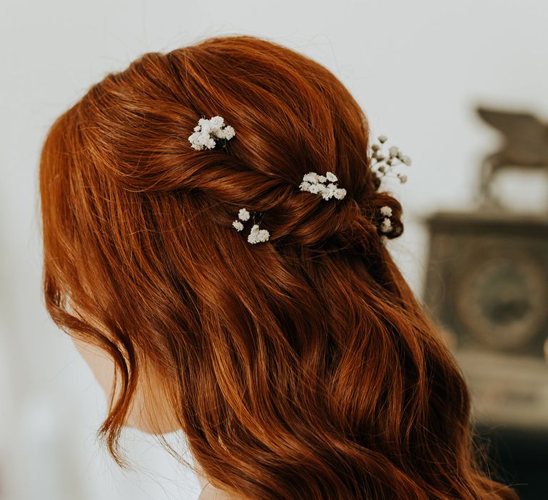 Bride with red hair in half up half down princess hairstyle decorated with white flower hair accessories 