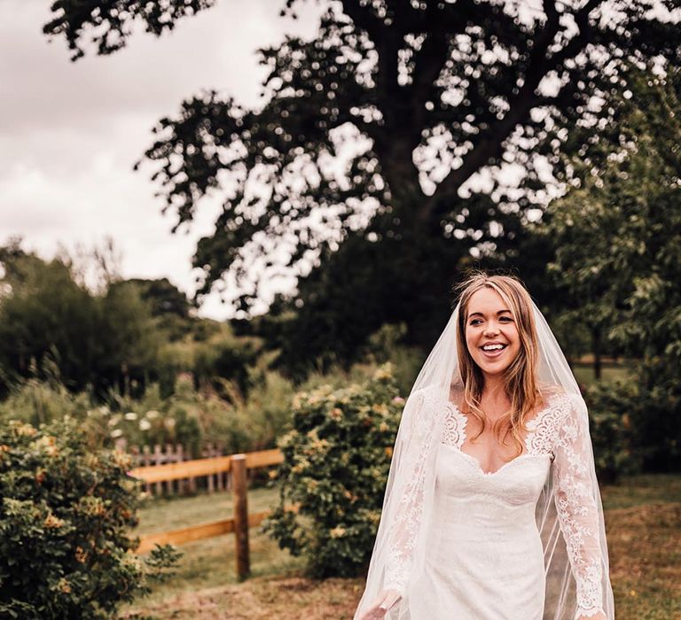 Bride in long sleeve lace wedding dress with embroidered edge veil 