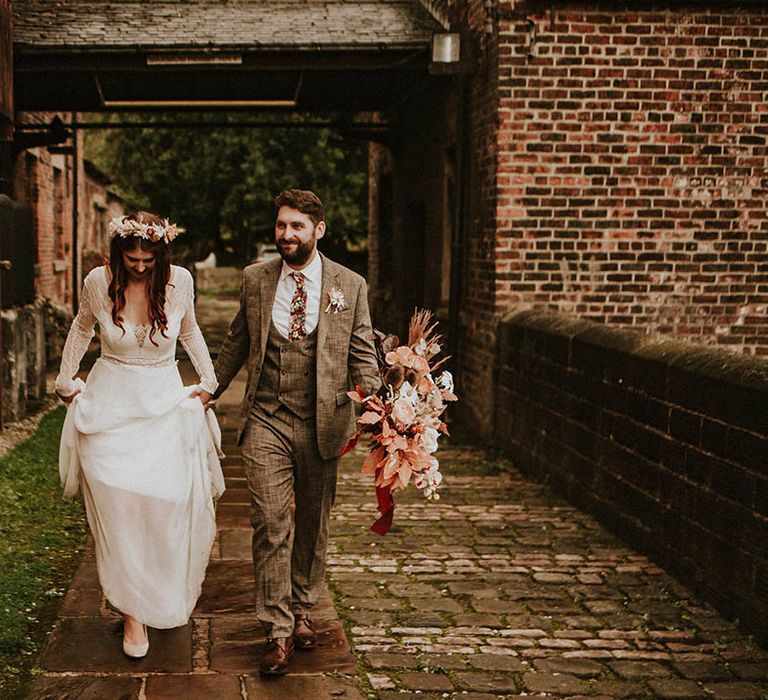 Groom in brown wedding suit with the bride in boho bridal dress and flower crown at their Yorkshire wedding 