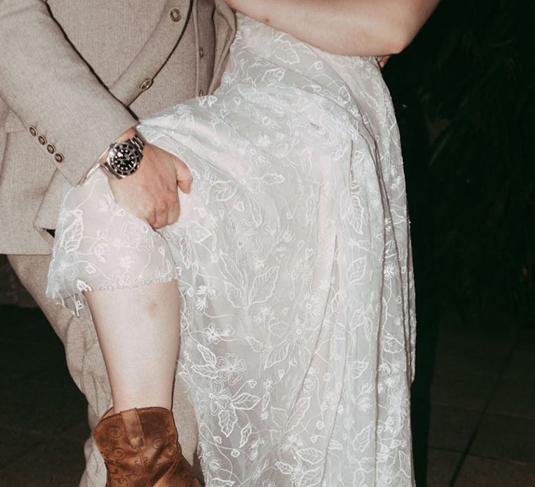 The bride and groom wear brown leather cowboy and cowgirl boots for the wedding 