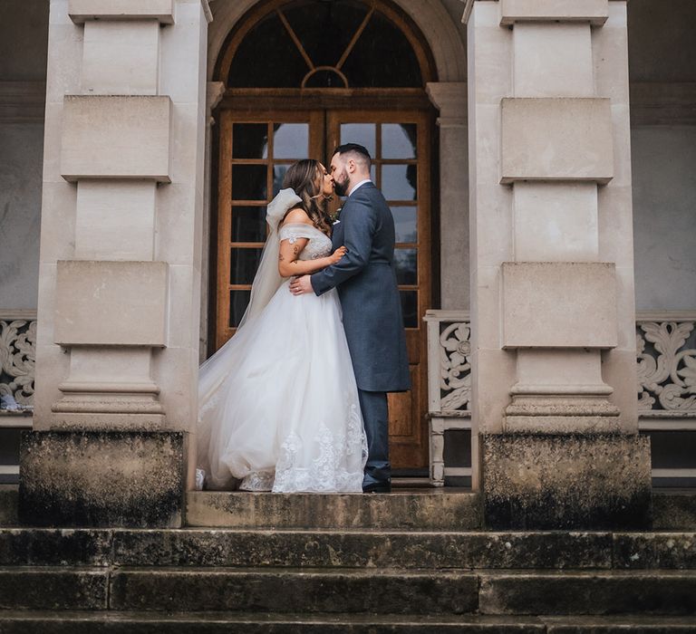 St Giles Christmas wedding with the bride and groom kissing for their couple portraits 