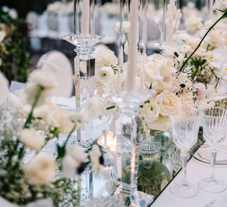 White wedding flowers and candles decorate the classic wedding tablescape at castle wedding venue in Italy 