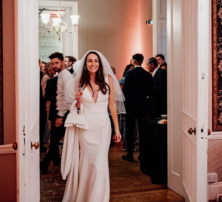 Bride carrying white Balenciaga wedding bag in Allure Bridals wedding dress 