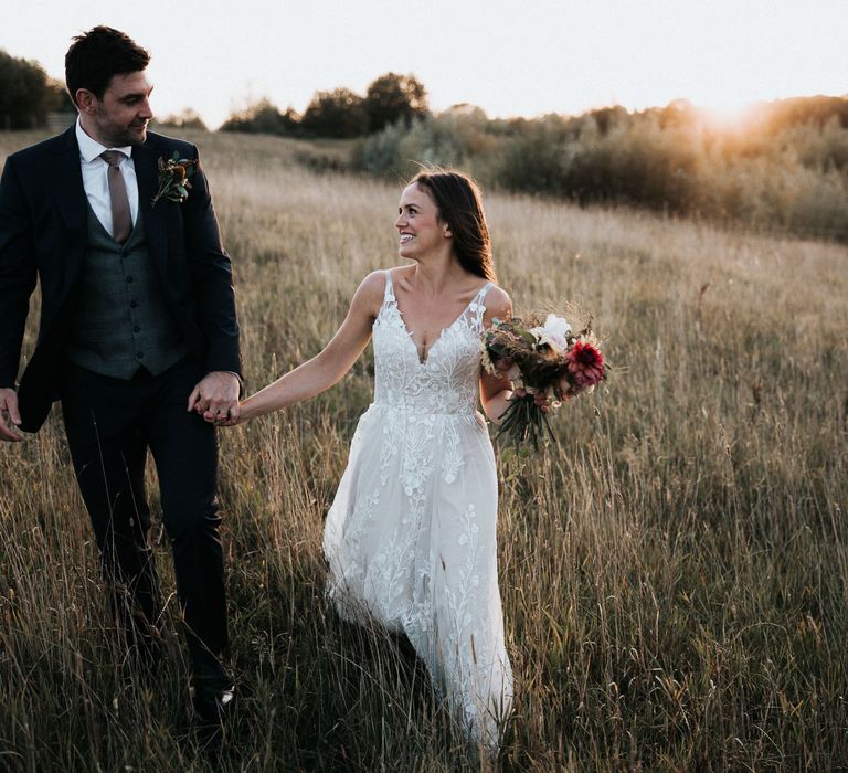 Bride and groom walking through the fields at Willow Marsh Farm