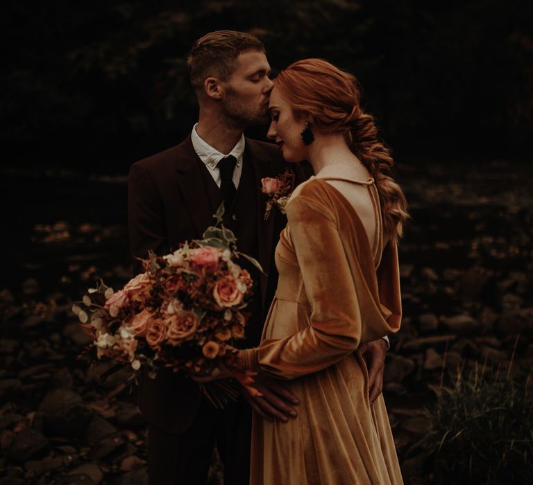 Bride in mustard velvet wedding dress with cowl back detail