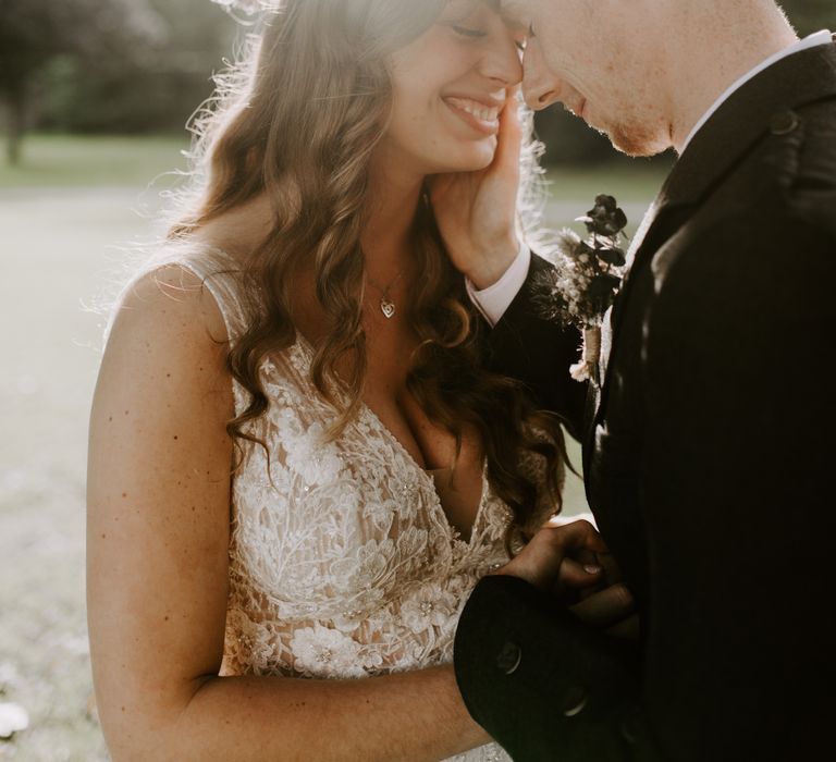 Bride and groom smile together with dried flower bouquet and boutonnière