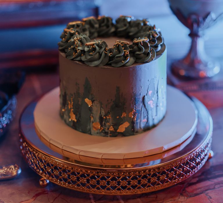 Darkly coloured wedding cake with gold leaf decoration 