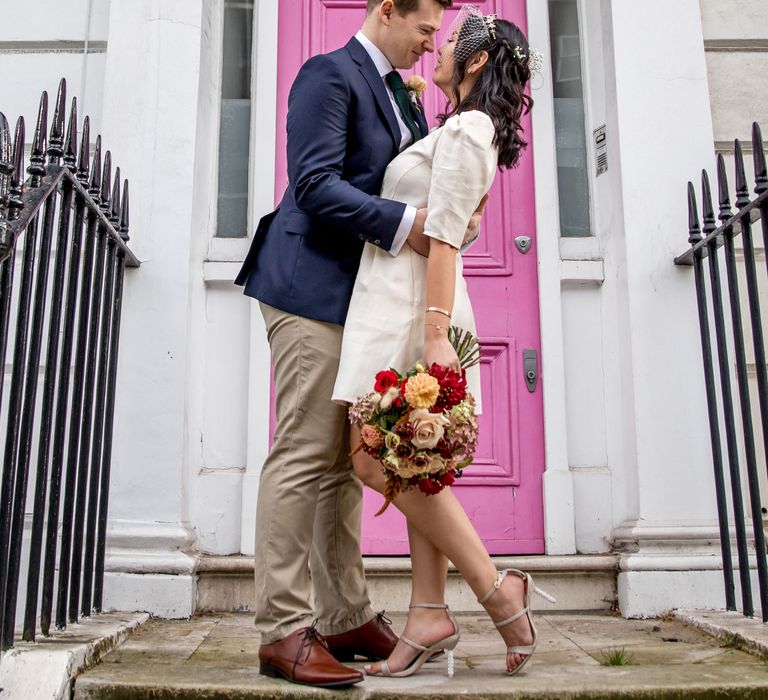 Bride and groom portrait outside the pink door in Chelsea with registry wedding dress