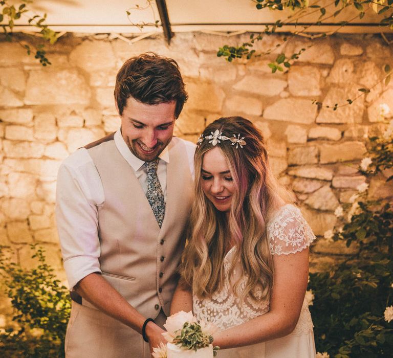 Bride and groom cut their three tier white naked wedding cake