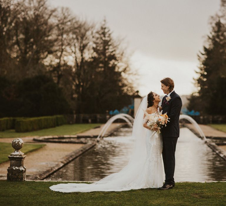 Bride and groom portrait by the fountains at Rhinefield House wedding venue