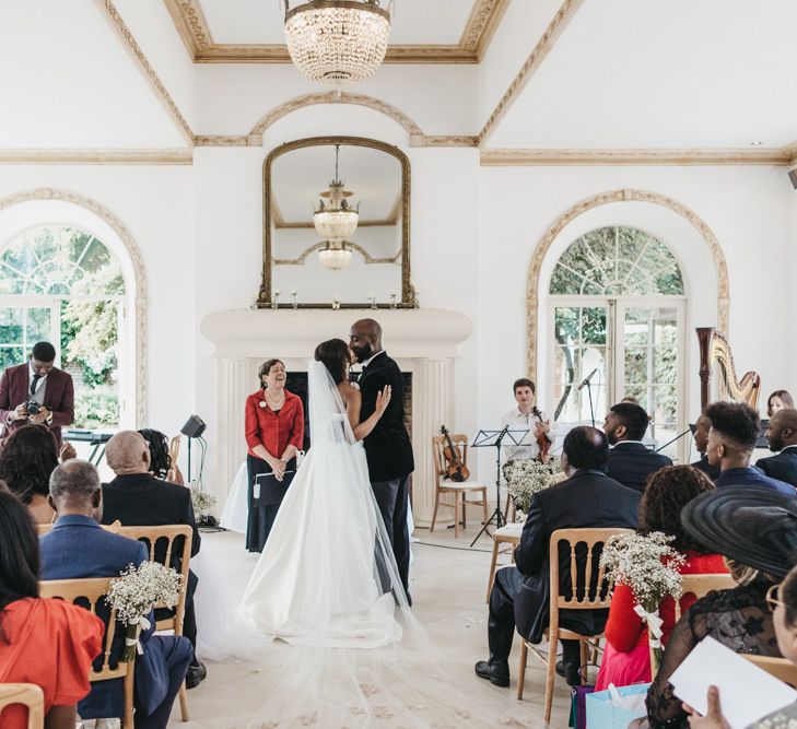 Bride and groom kissing at the altar of their Northbrook Park wedding ceremony 