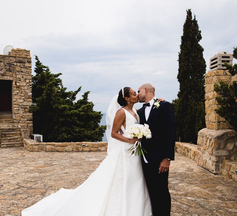 The bride and groom kiss at their chateau wedding in south of France